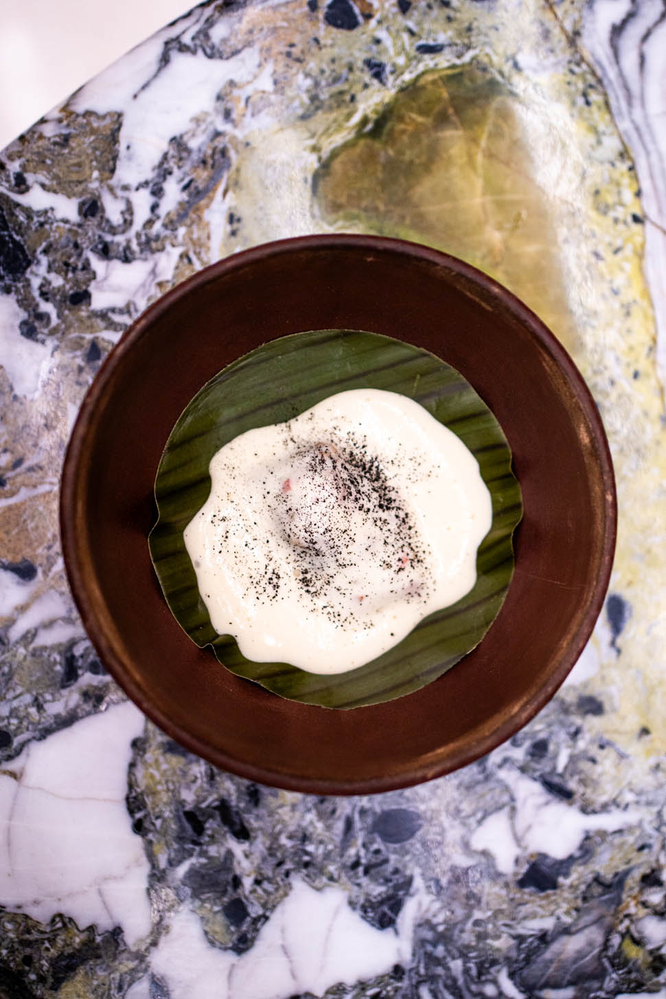 jorge vallejo tamal di anatra pibil anatra cotta sotto terra servito su una foglia di banana con crema di mais
